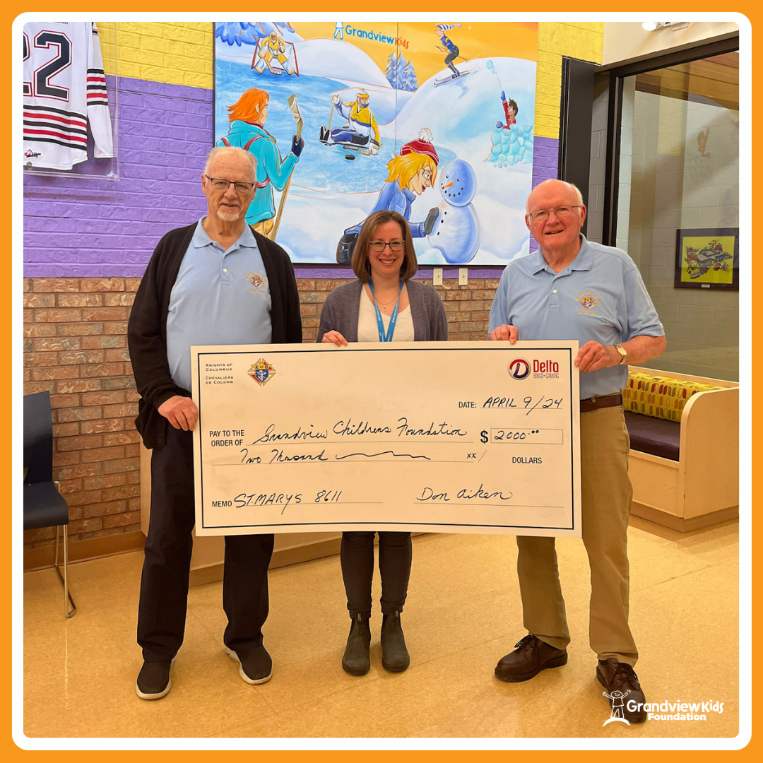 Two men and one woman standing while holding a large cheque made out to Grandview Kids Foundation for two thousand dollars
